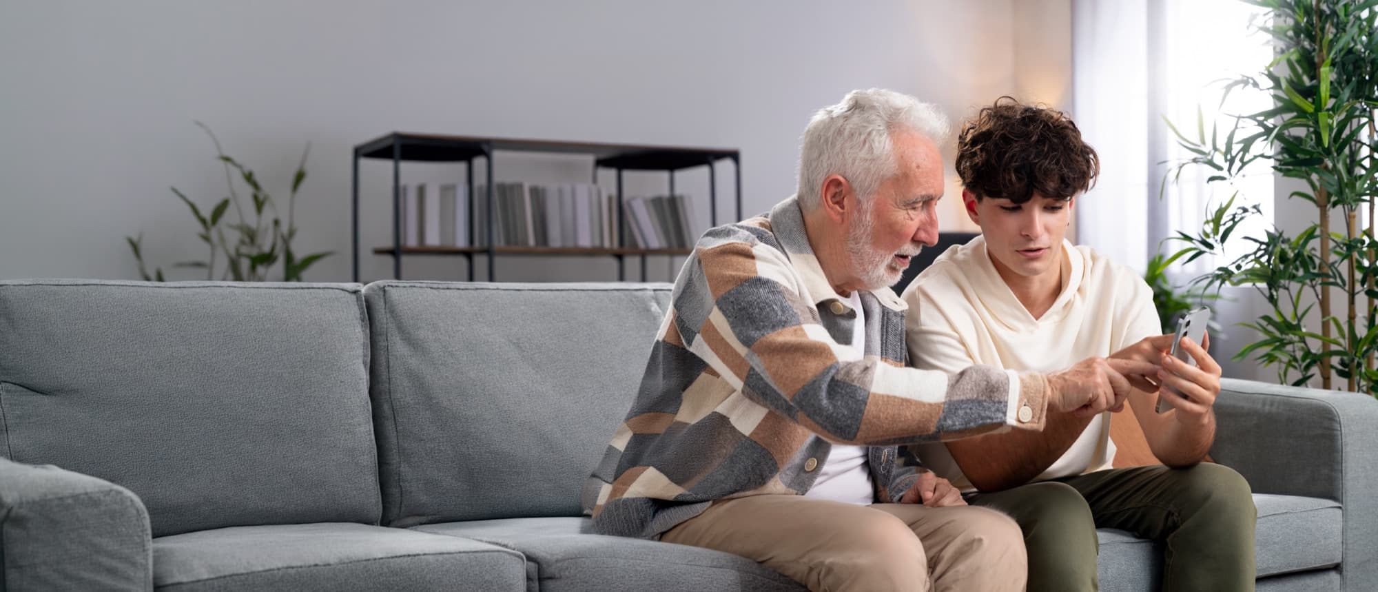 An elder and a younger family member looking at a phone together